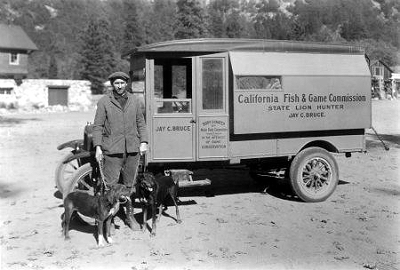Photo of Jay Bruce with hounds in front of truck, text: State Lion Hunter.
