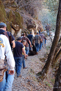Long line of hunters on a mountain trail.