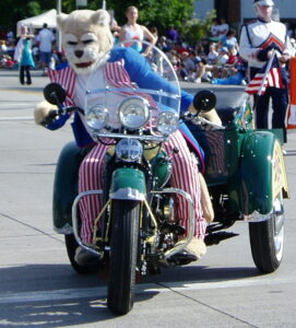 BYU mascot Cosmo the Cougar, a person in a fursuit, on a motorcycle