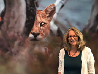 Sharon Negri, in front of a photo of a mountain lion